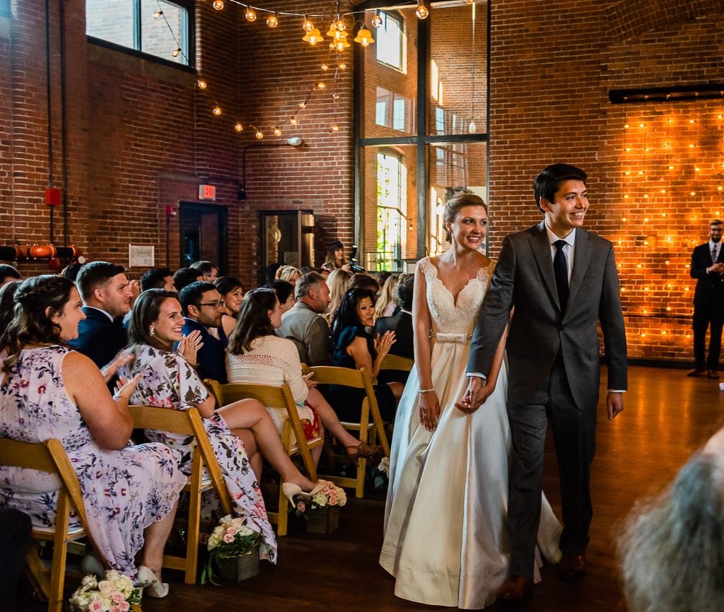 Bride and Groom just married walking down the aisle at wedding at Charles river museum of industry and innovation