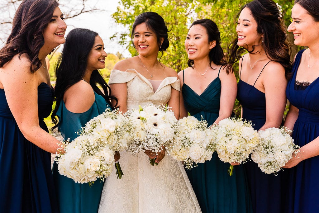 Bride and Bridesmaids with flowers laughing