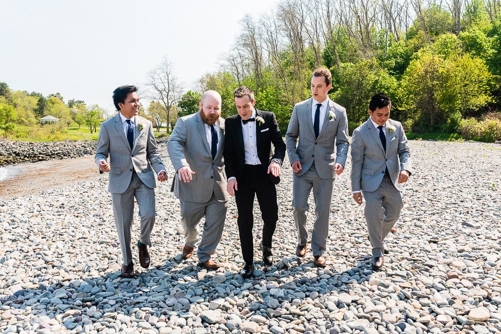 Groom and groomsmen dancing on a beach at the wedding