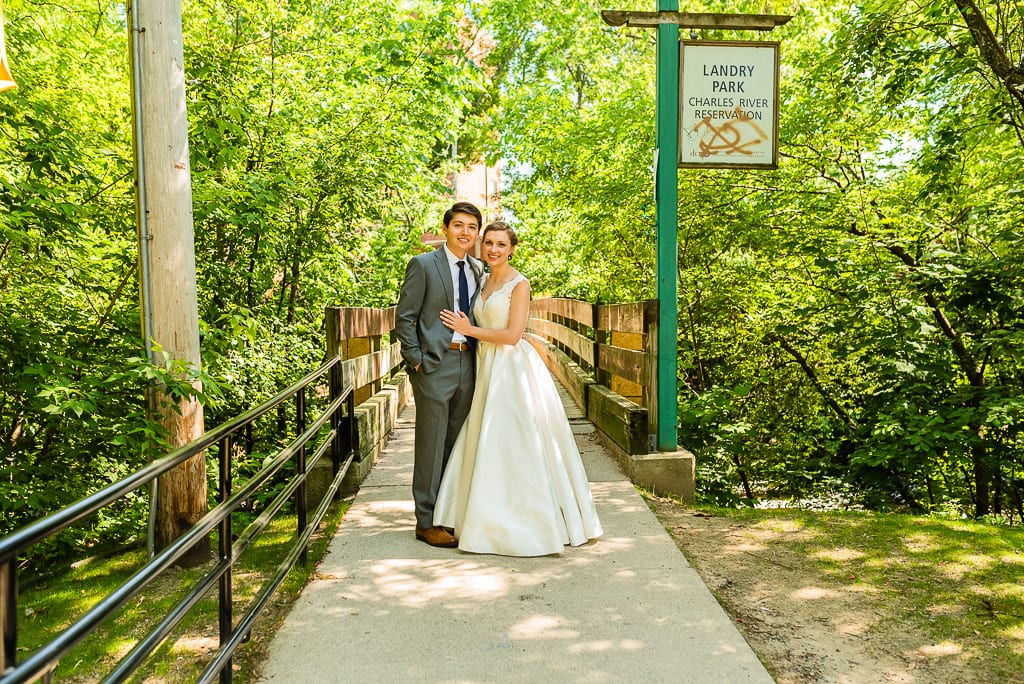 Bride and groom standing on bridge at Landry Park in Charles River Reservation