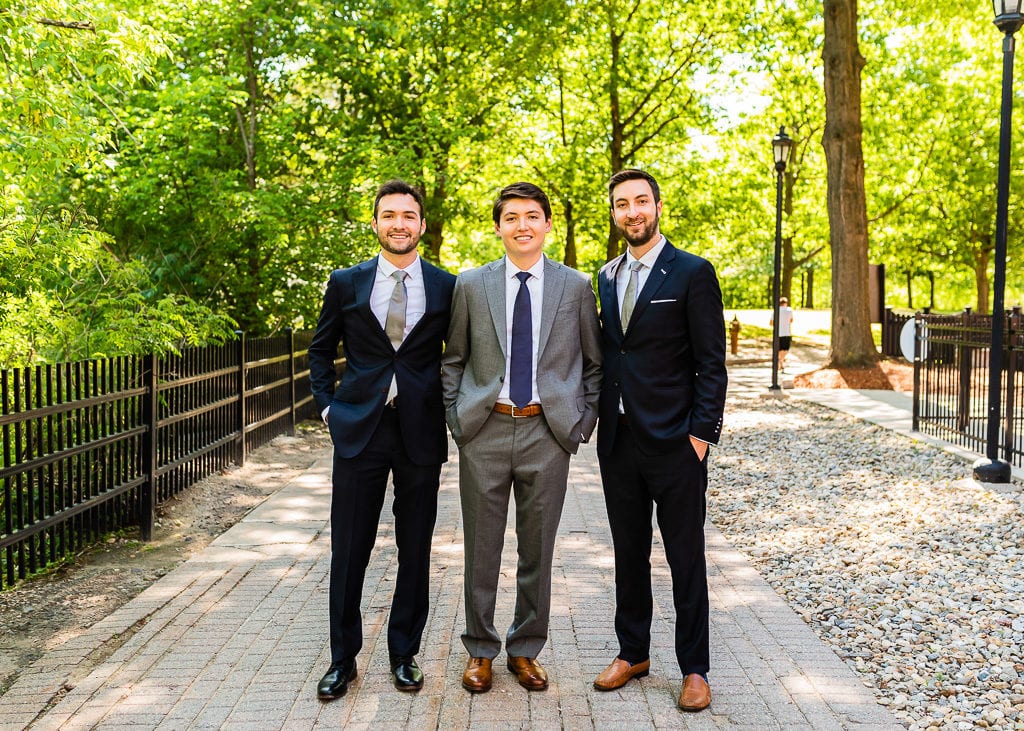 Groom in gray and groomsmen in navy at a park