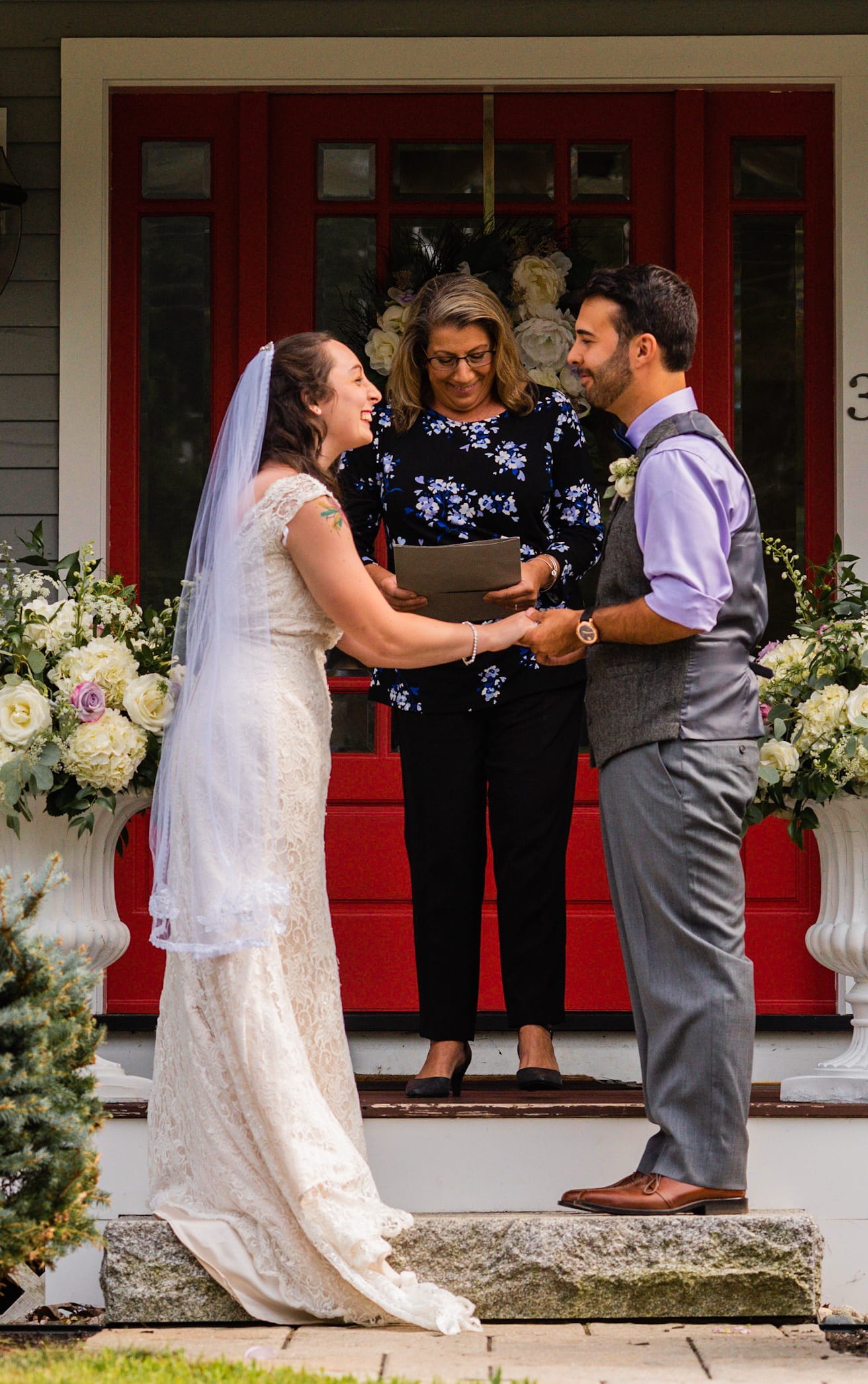 bride and groom smile on front porch